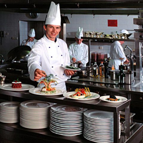 Kucharz podający potrawy w kuchni restauracji — fotografia kulinarna